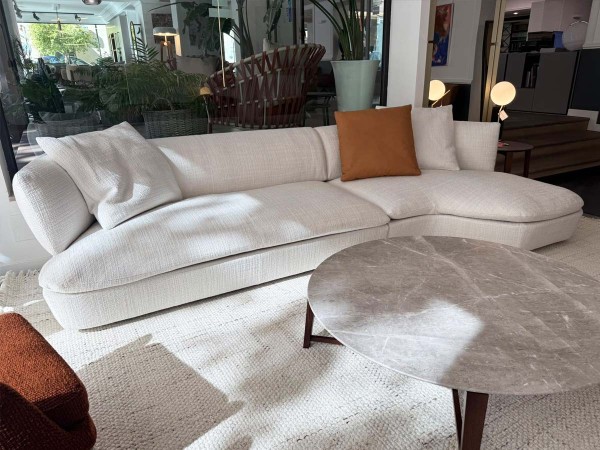Flexform Quincy curved corner sectional sofa in light fabric at the Mobilificio Marchese showroom in Messina, Italy