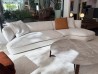 Sofá rinconera curvo Flexform Quincy en tejido claro en el showroom de Mobilificio Marchese en Mesina